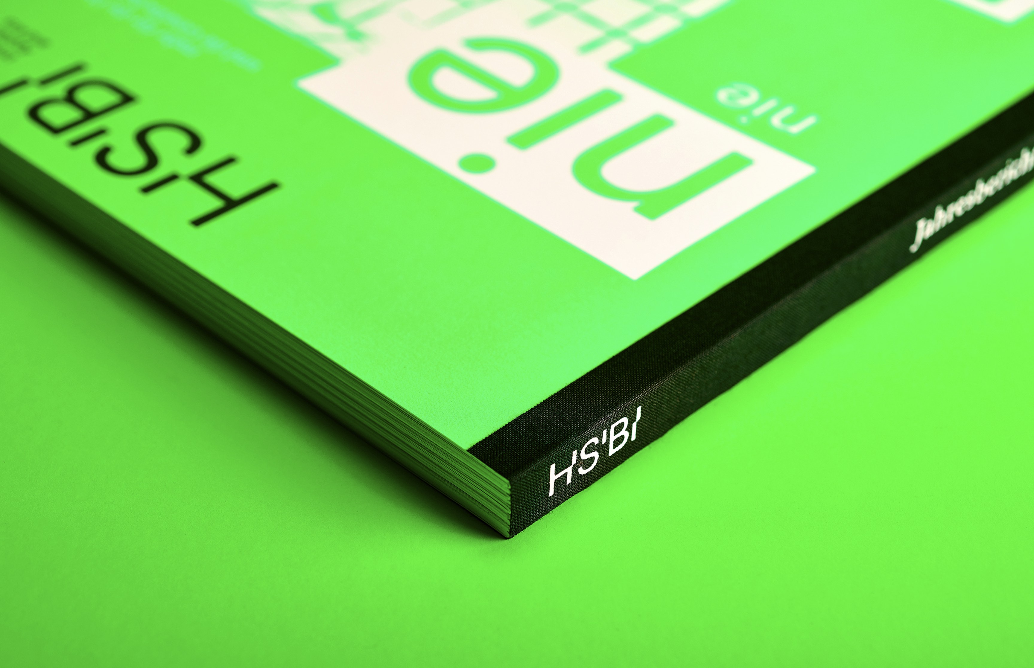 Detailaufnahme des Jahresberichts 2023 der Hochschule Bielefeld mit leuchtend grünem Umschlag – Editorial Design von Neue Identität Bielefeld.