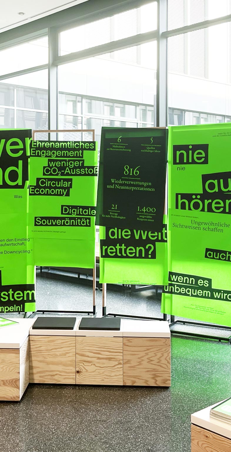 Messestand der Hochschule Bielefeld mit plakativer Ausstellungsgestaltung zum Jahresbericht 2023 – Kommunikationsdesign von Neue Identität Designagentur Bielefeld.